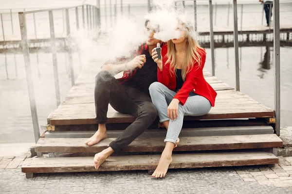 Elegante giovane coppia con vaporizzatore in una città — Foto Stock