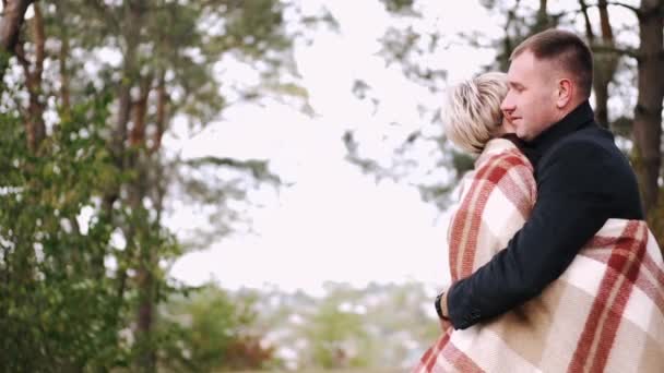 Porait de pareja cubierta de manta abrazándose en el bosque — Vídeo de stock