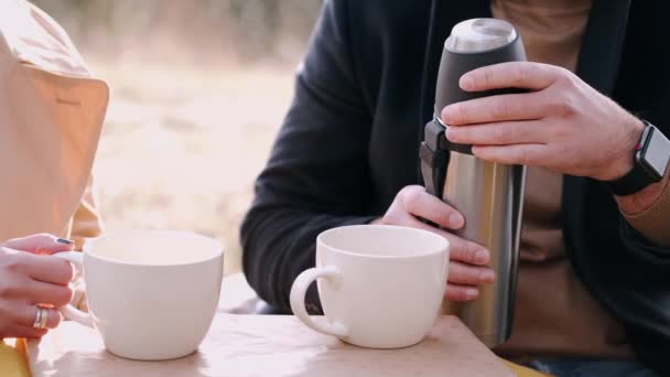 Beskuren utsikt över termos och koppar te ute i skogen — Stockvideo