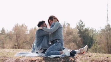 Sevgi dolu bir çift gün batımında tarlada öpüşüyor.