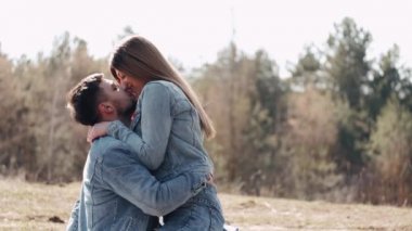 Sevgi dolu bir çift gün batımında tarlada öpüşüyor.