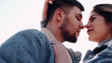 Sevgi dolu bir çift gün batımında tarlada öpüşüyor.