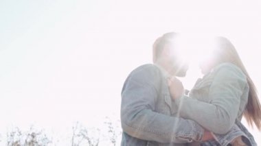 Sevgi dolu bir çift gün batımında tarlada öpüşüyor.