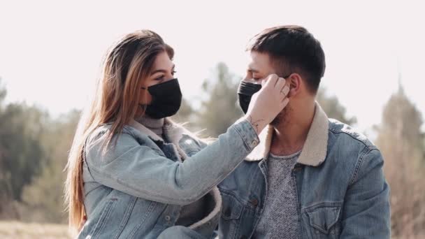 Ένα ζευγάρι με μάσκες φιλιούνται το ηλιοβασίλεμα στο χωράφι. — Αρχείο Βίντεο