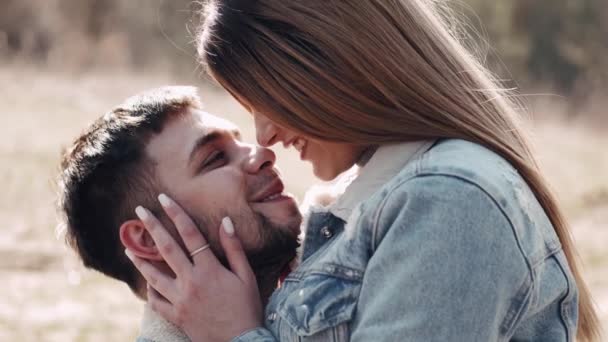 Het liefdevolle paar van man en vrouw kussen bij zonsondergang in het veld — Stockvideo