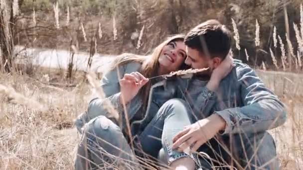 O casal amoroso de homem e mulher estão se beijando ao pôr do sol no campo de trigo — Vídeo de Stock
