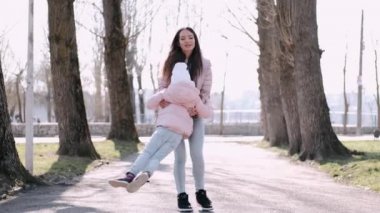 Güzel anne parkta güzel bir kızla yürüyor.