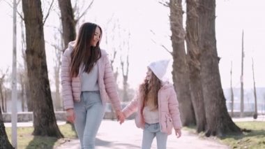 Güzel anne parkta güzel bir kızla yürüyor.