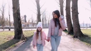 Güzel anne parkta güzel bir kızla yürüyor.
