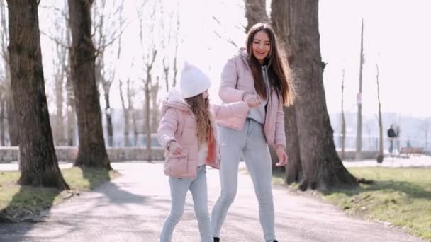 Vacker mor går med en söt dotter i en park — Stockvideo