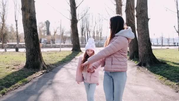 Vacker mor går med en söt dotter i en park — Stockvideo