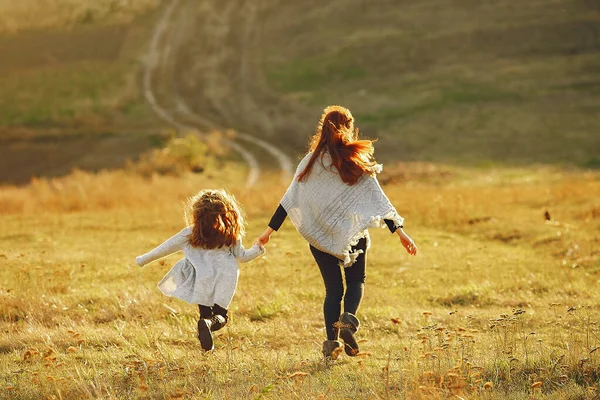 Madre con hija pequeña jugando en un campo de otoño —  Fotos de Stock