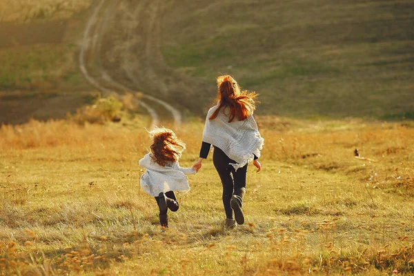 Matka s malou dcerou hrající si na podzimním poli — Stock fotografie