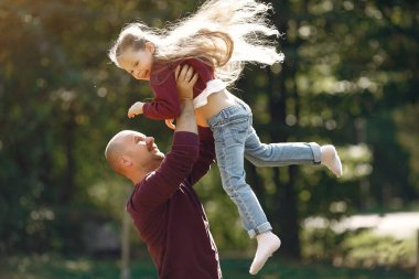 Sonbahar parkında oynayan sevimli bir aile.