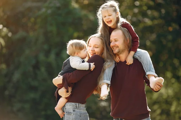 Familie mit niedlichen Kindern in einem herbstlichen Park — Stockfoto