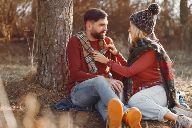 Bahar ormanında ağacın yanında oturan bir çift.