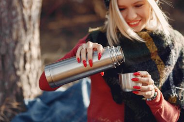 Bahar ormanında, ağacın yanında oturan kız.