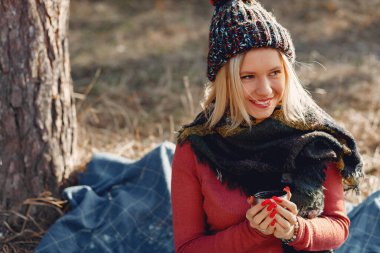 Bahar ormanında, ağacın yanında oturan kız.