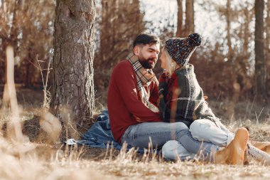 Bahar ormanında ağacın yanında oturan bir çift.
