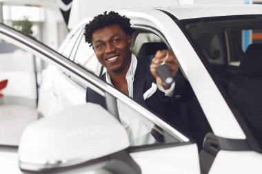 Yakışıklı ve zarif bir siyah adam bir araba salonunda.