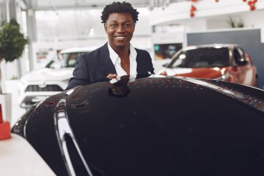 Yakışıklı ve zarif bir siyah adam bir araba salonunda.