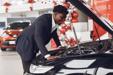 Yakışıklı ve zarif bir siyah adam bir araba salonunda.