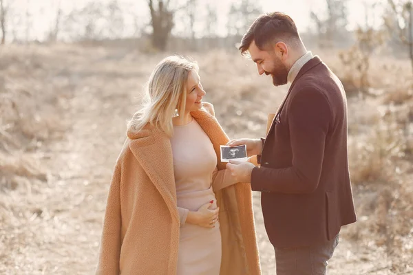 Mulher grávida de pé em um parque com o marido — Fotografia de Stock