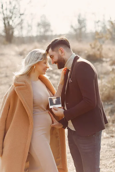 Gravid kvinna som står i en park med sin man — Stockfoto