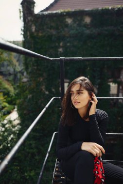 güzel esmer siyah bir merdiven üzerinde poz