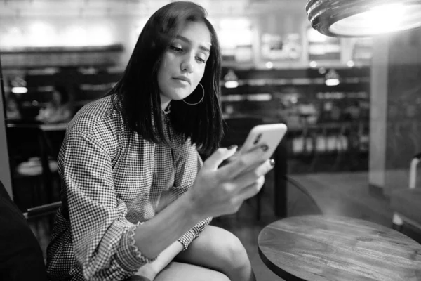 Брюнетка девушка с помощью мобильного телефона, чтобы связаться с другом — стоковое фото