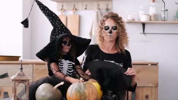 Мать и дочь в костюмах на Хэллоуин играют вместе на кухне — стоковое видео