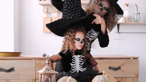 Moeder en dochter in halloween kostuums spelen samen in de keuken — Stockvideo