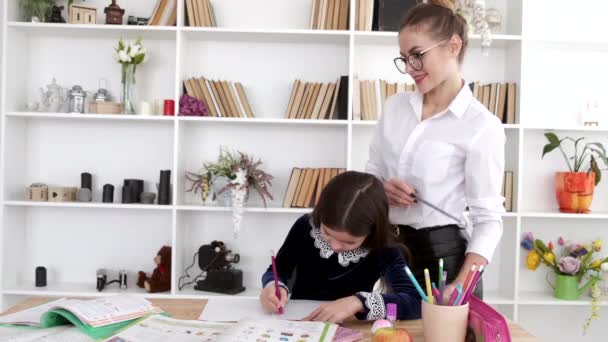 Tutor relojes alumno hacer la tarea después de la escuela en la biblioteca — Vídeo de stock