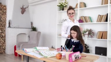 Öğretmen, öğrencinin okuldan sonra kütüphanede ödev yapmasını izliyor.