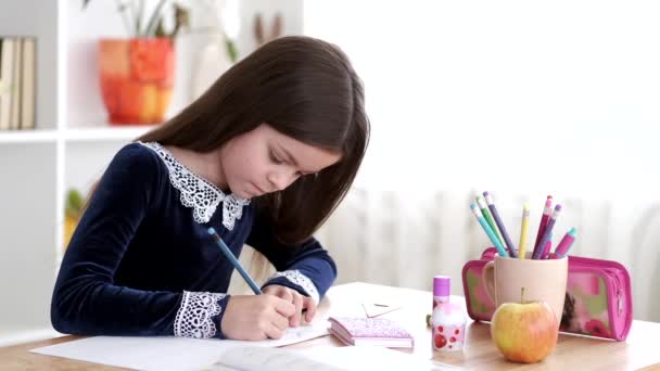 Portrait of brunette girl doing homework in school library — Stock Video