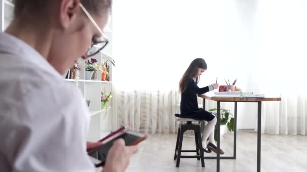 Matka používá telefon, zatímco dítě dělá domácí úkoly — Stock video