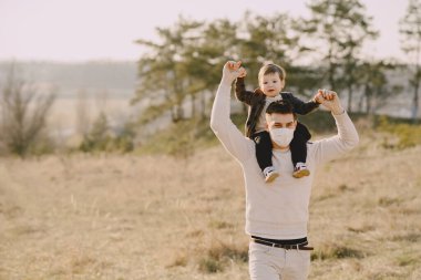 Maskeli küçük oğlu olan baba.