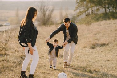 Bir bahar tarlasında yürüyen şık bir aile