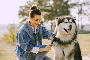 Köpeğiyle bahar tarlasında şık bir kız.
