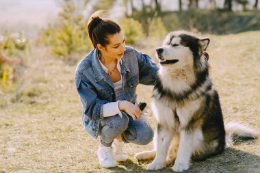 Köpeğiyle bahar tarlasında şık bir kız.