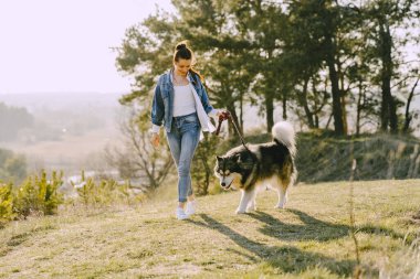 Köpeğiyle bahar tarlasında şık bir kız.