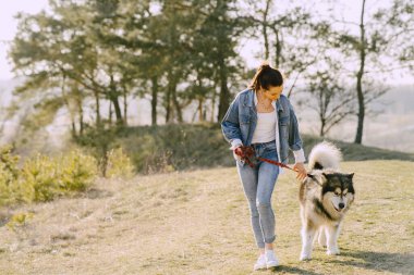 Köpeğiyle bahar tarlasında şık bir kız.