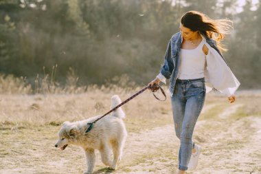 Köpeğiyle bahar tarlasında şık bir kız.