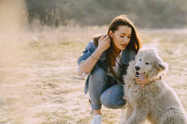 Köpeğiyle bahar tarlasında şık bir kız.