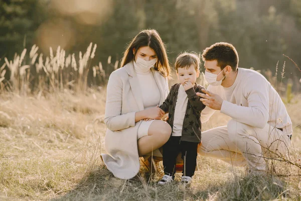 Famille élégante dans un masque marchant sur un champ de printemps — Photo