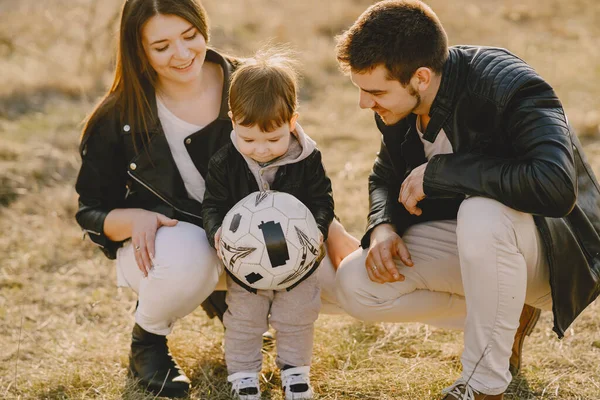 Família elegante que anda em um campo de primavera — Fotografia de Stock