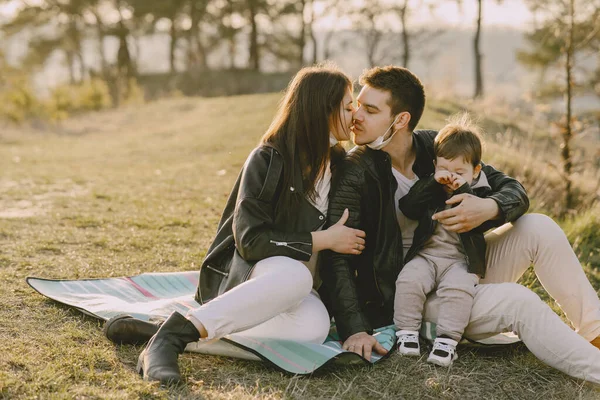 Família elegante sentado em um campo de primavera — Fotografia de Stock