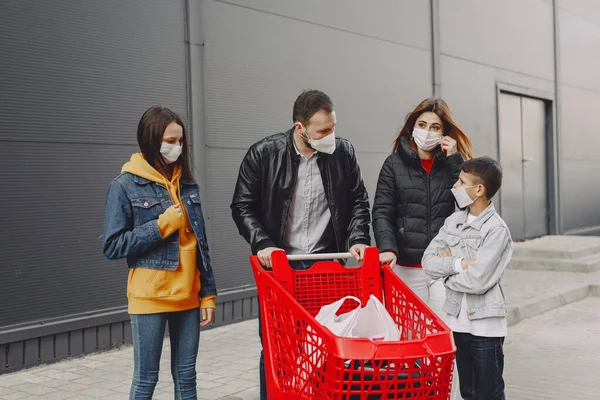 Family in protective masks with purchases