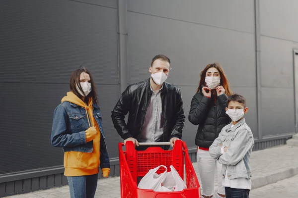 Familia en máscaras protectoras con compras —  Fotos de Stock