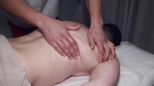 Fizyoterapist masaj odasında hastaya sırt masajı yapıyor. — Stok video